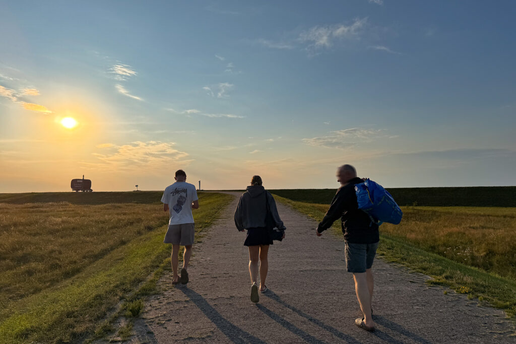 menschen gehen den Deich hoch zur Saunli in Heidkate